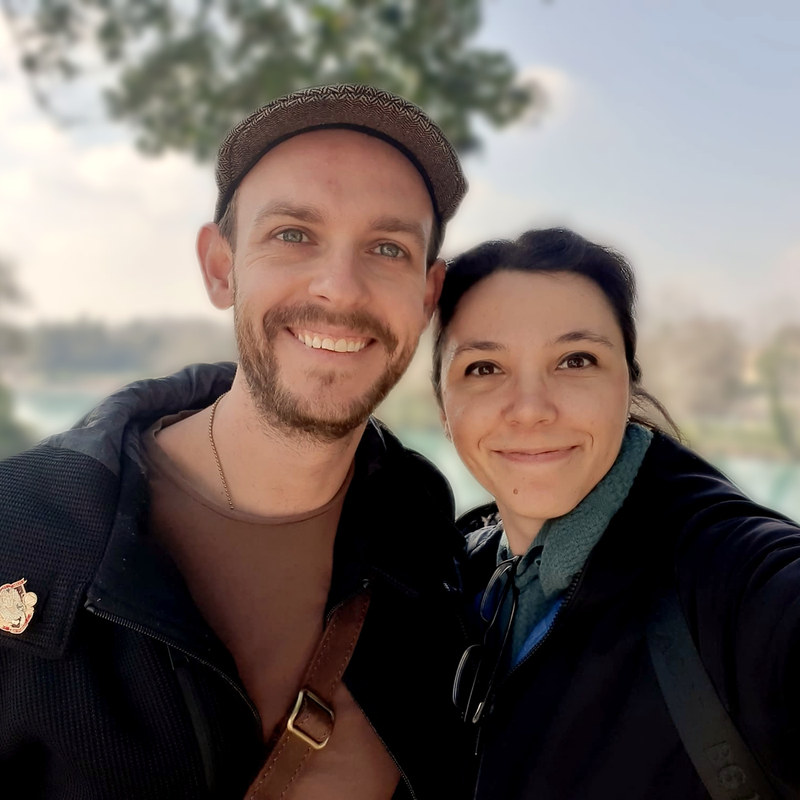 Cassidy and his wife by a river on a bright afternoon.